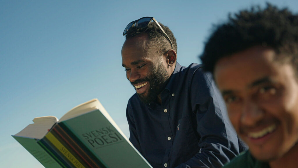 Två glada personer läser en bok