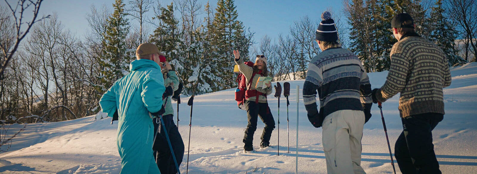 Guide som visar gruppen vilken riktning de ska skida